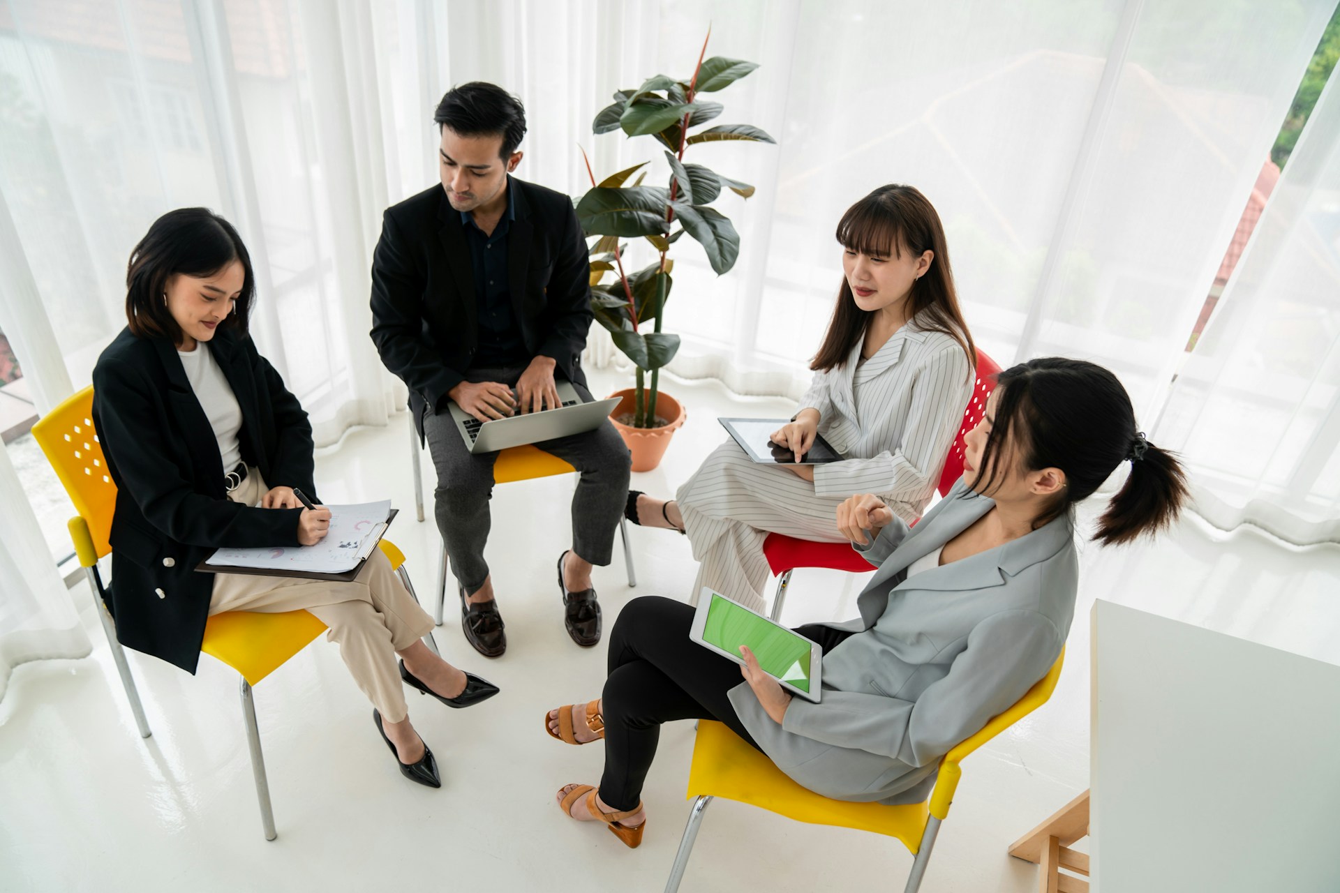 four coworkers sitting in a circle discussing work