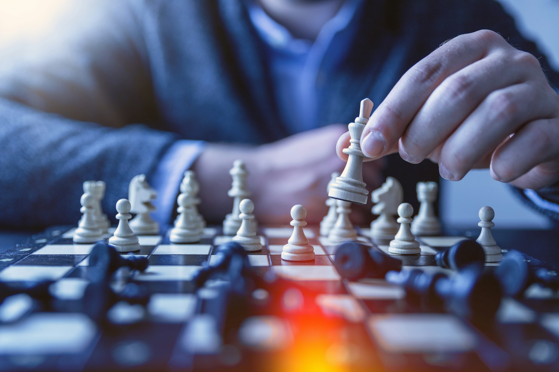 a man moving a piece in a game of chess