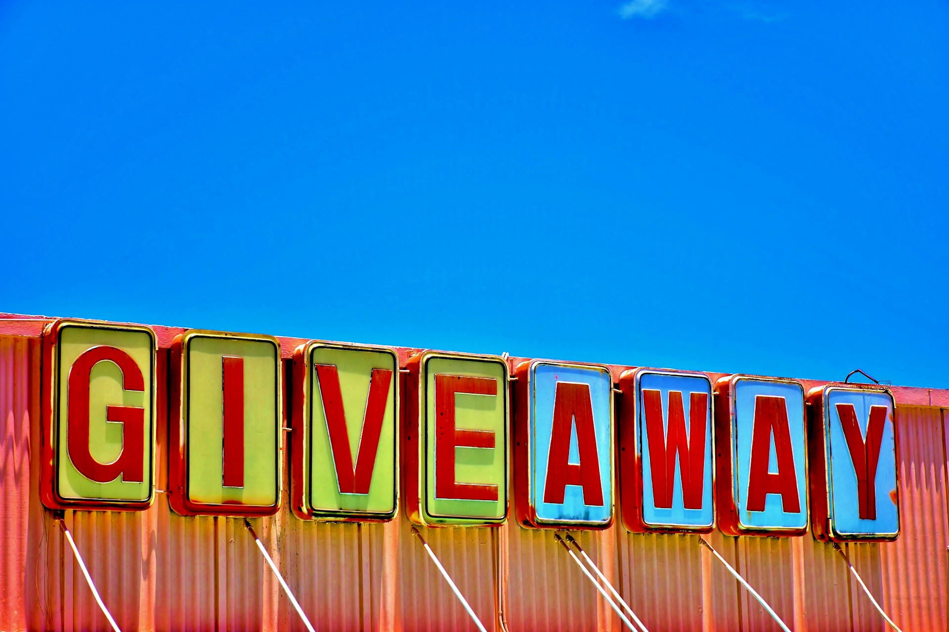 a retro sign on a roof saying 'giveaway'