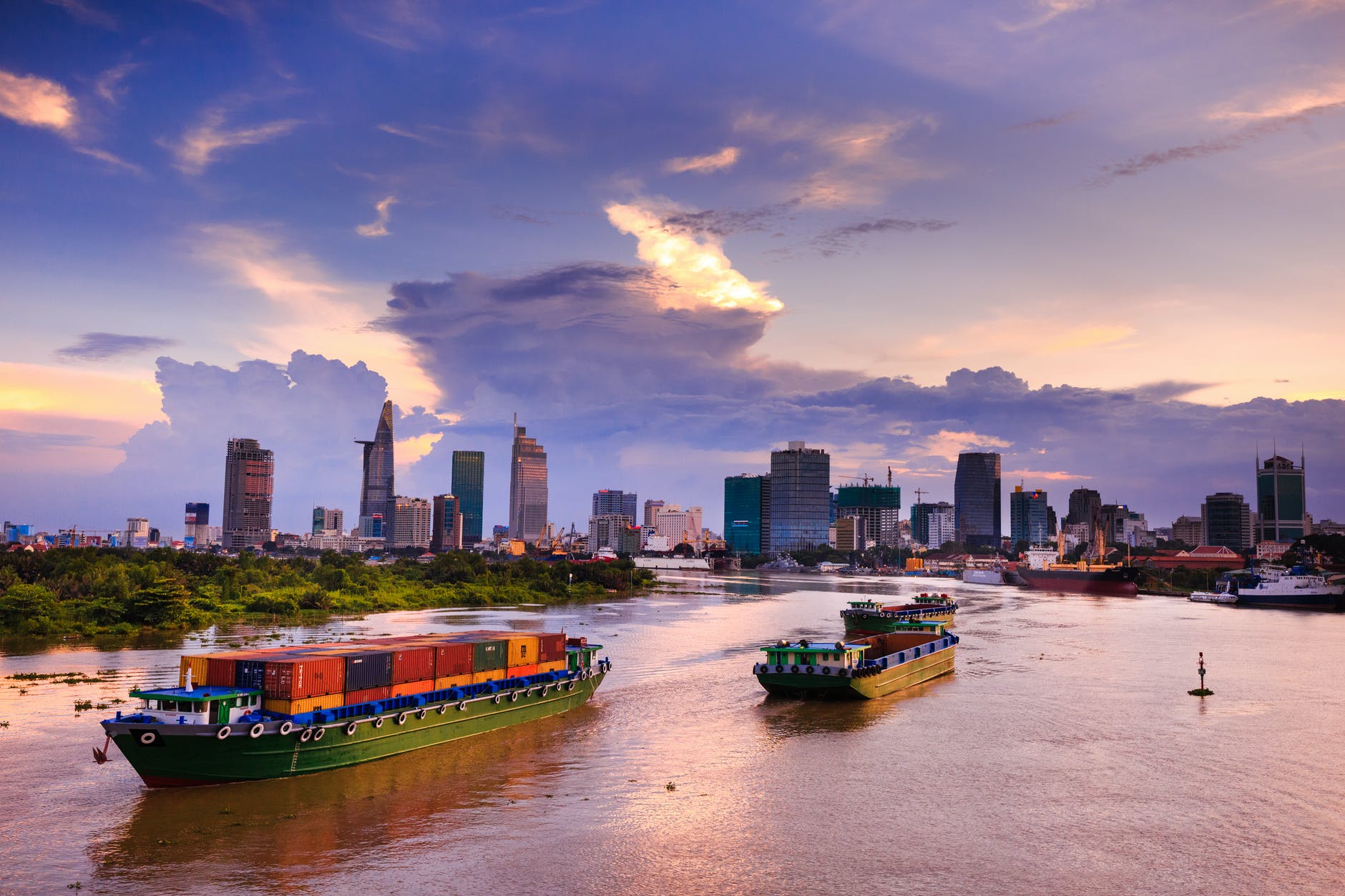 small cargo ships with a city skyline behind them