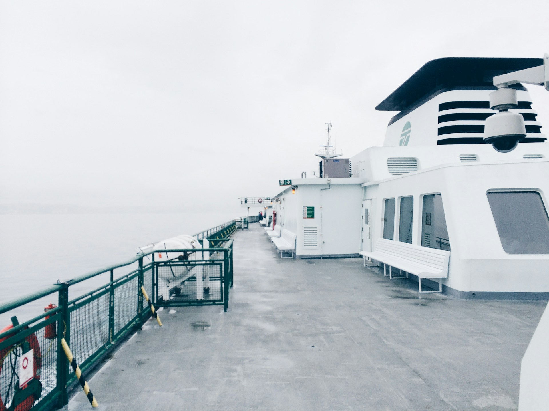 a ship with an empty deck under a gray misty sky