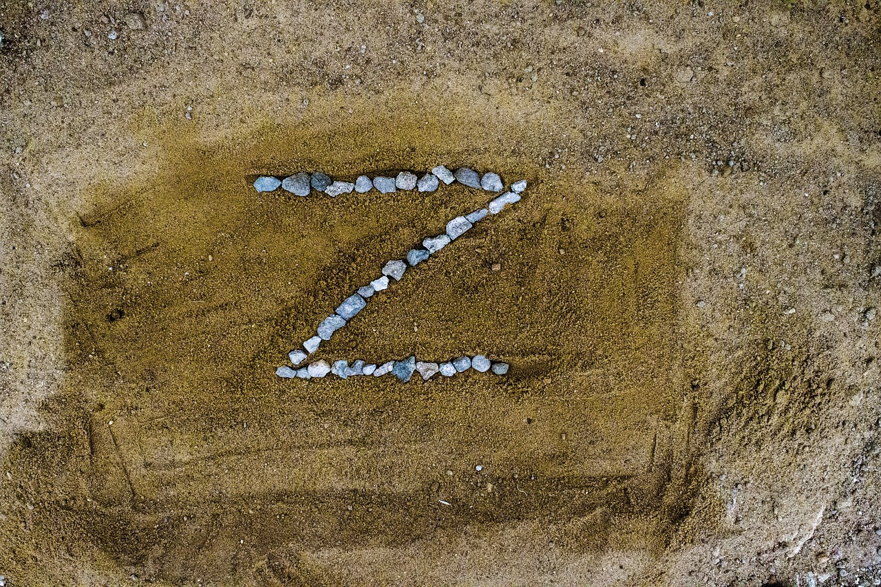 the letter Z spelt out in pebbles on sand