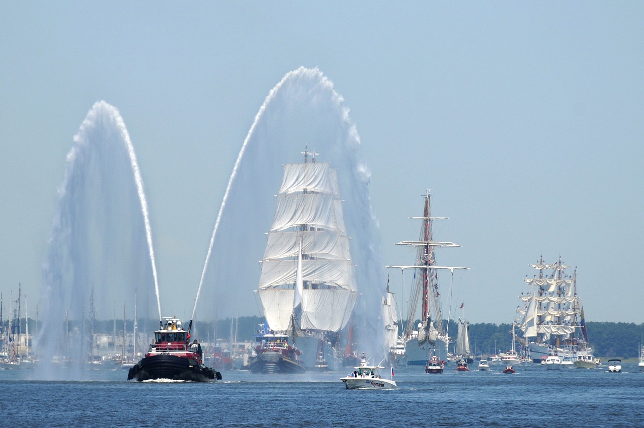 a fireboat welcoming a tall ship