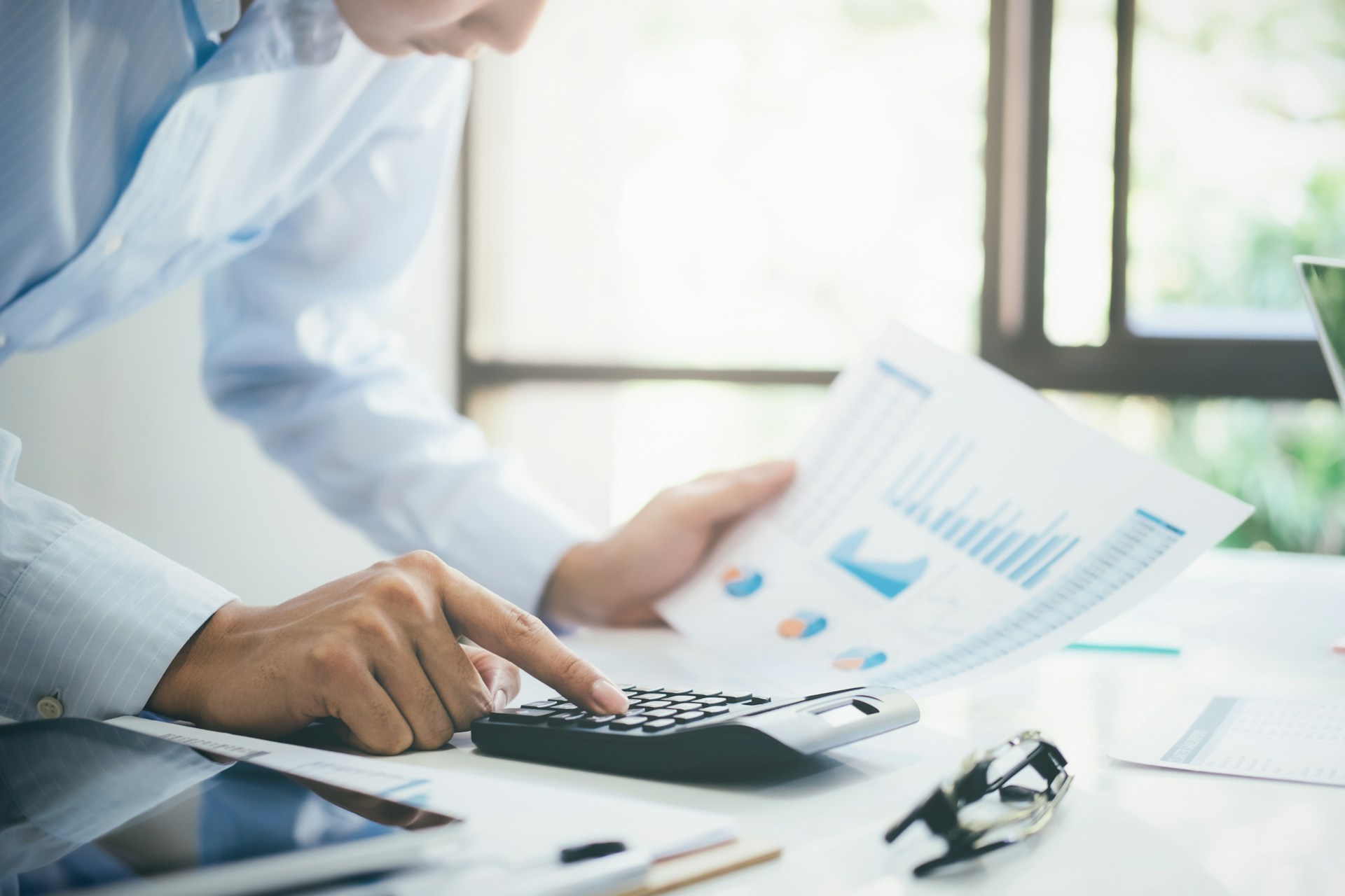 A man looking at graphs and using a calculator