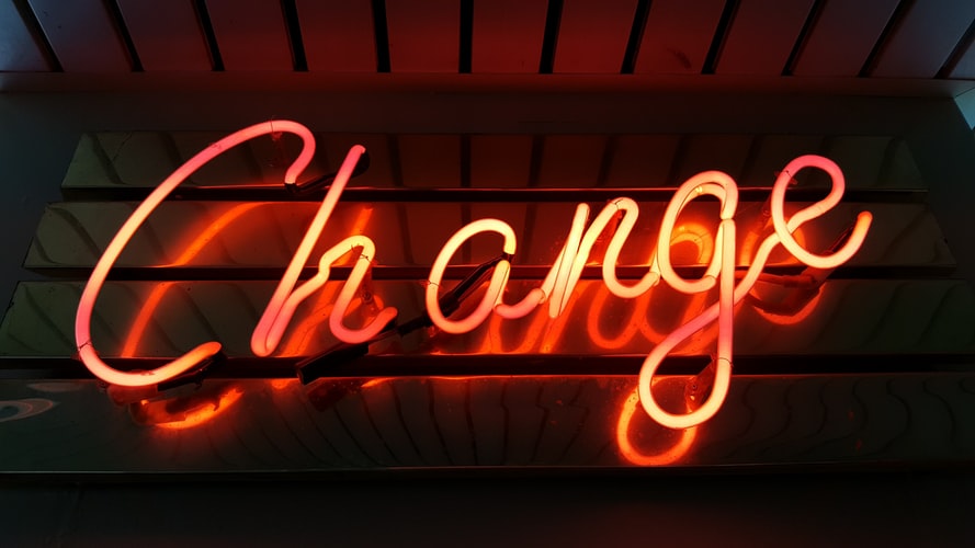 an orange neon sign saying 'change'