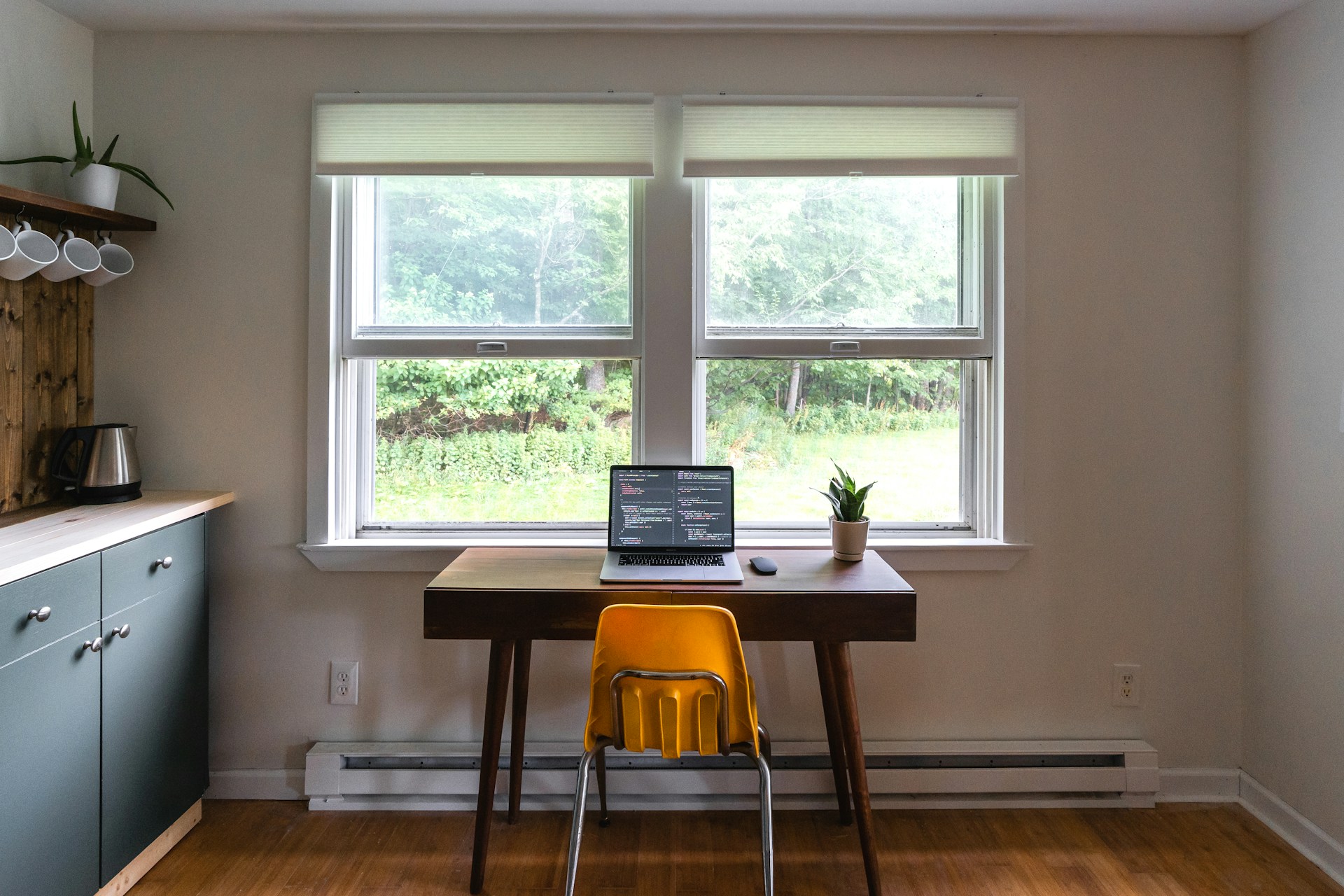 a desk in a domestic kitchen with a laptop on it