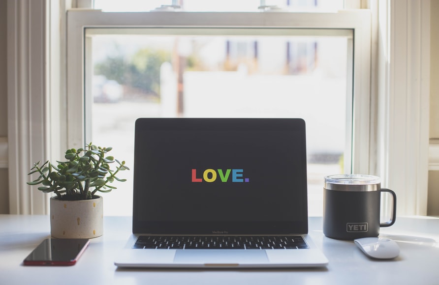 a laptop in a home office with the word 'love' on the screen