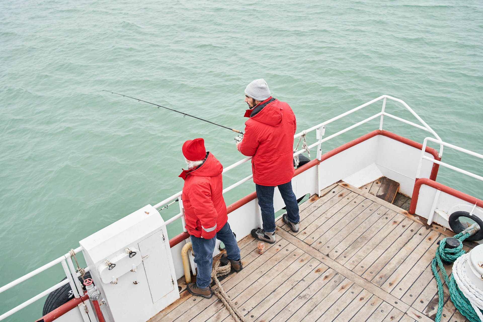 two people on the deck of a recreational fishing boat