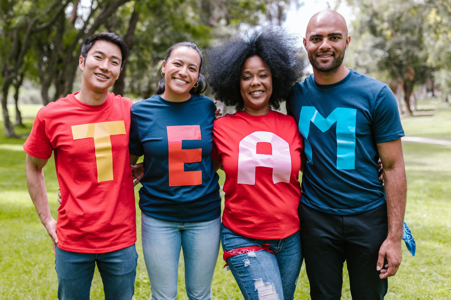 four people wearing t-shirts that spell out 'team'