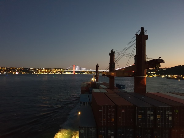 containership sailing towards a port at night