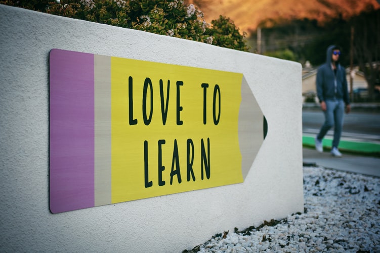 a sign shaped like a pencil with the words 'love to learn' on it 