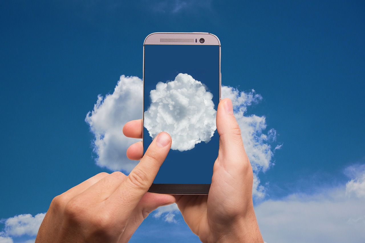 a finger pointing to a cloud on a phone screen