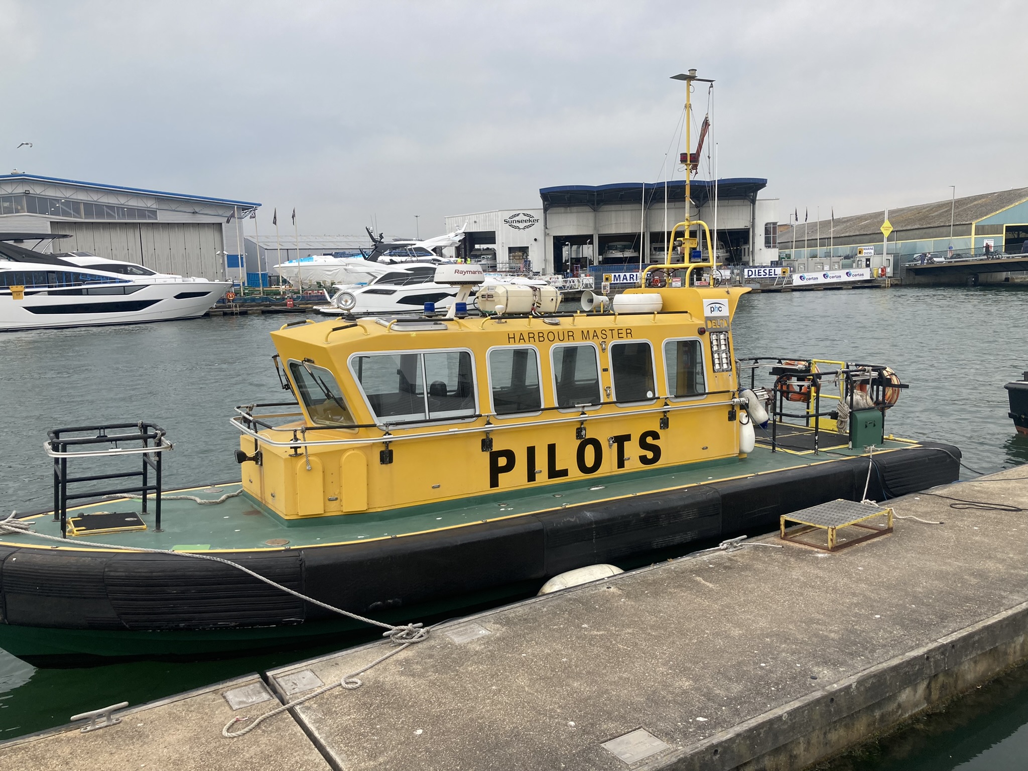 a yellow pilot boat moored in a harbor