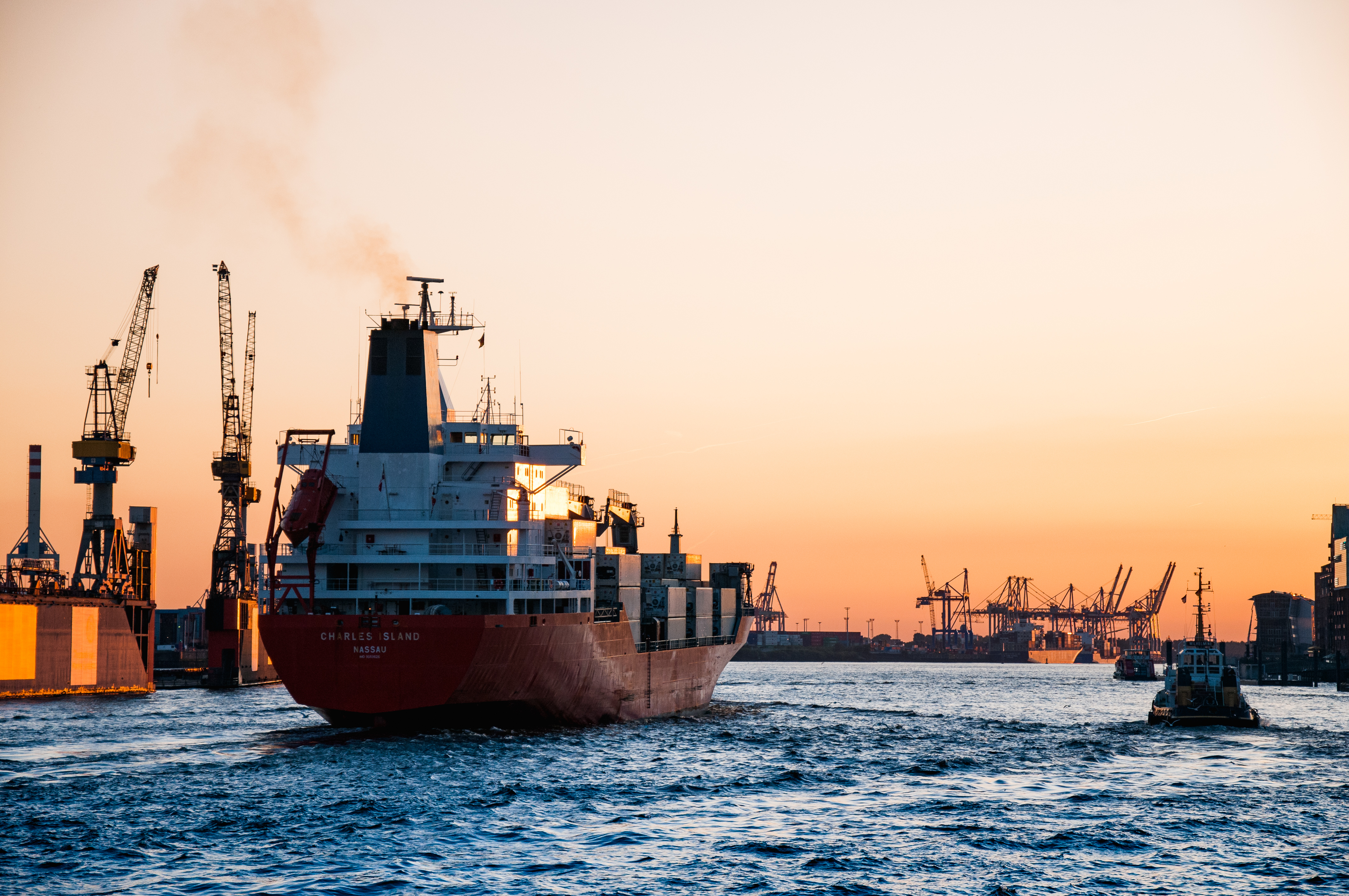 a smaller cargo ship in port at sunset