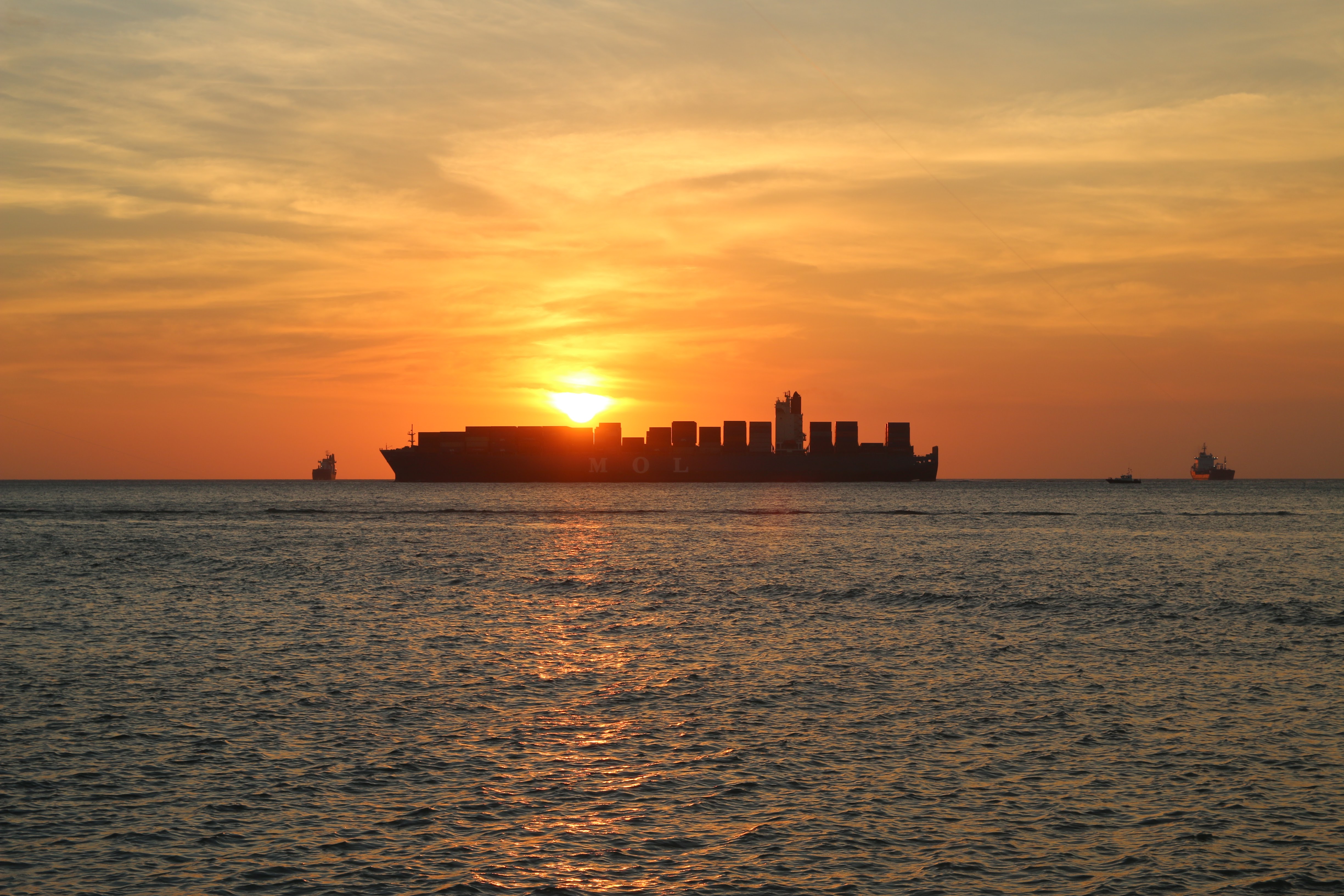 silhouette of a cargo ship at sunset